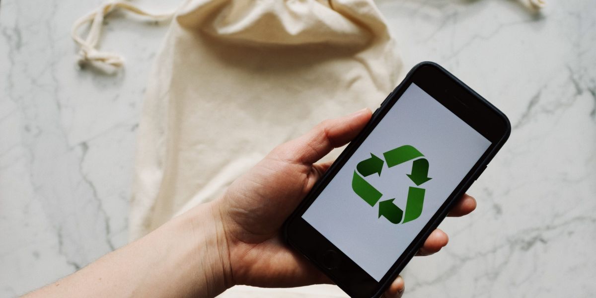 Free Faceless person showing recycle symbol on mobile phone screen Stock Photo